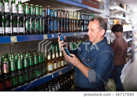 European selecting a beer at the grocery store European selecting a beer at the grocery store 36717890