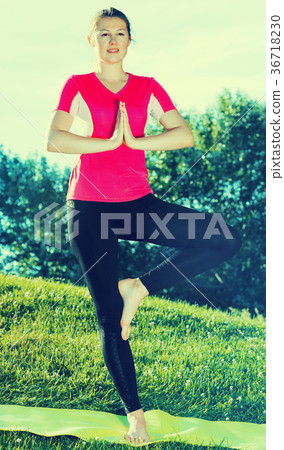 Female in pink T-shirt is staying and practising meditation Female in pink T-shirt is staying and practising meditation 36718230