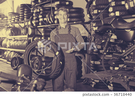 Man standing with new tires for motorbike Man standing with new tires for motorbike 36718440