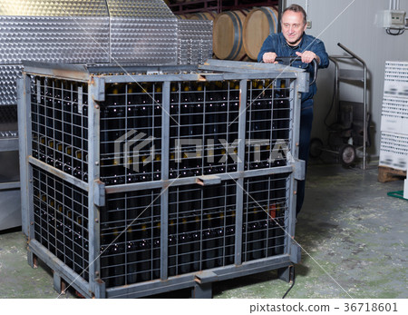 Wine maker unloads containers with bottles 36718601