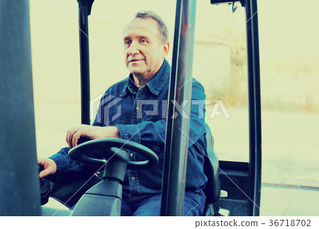 Elderly man of winery goes on loader Elderly man of winery goes on loader 36718702