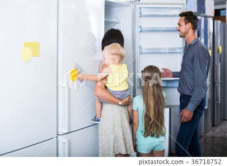 family of four shopping new refrigerator in home appliance store family of four shopping new refrigerator in home appliance store 36718752