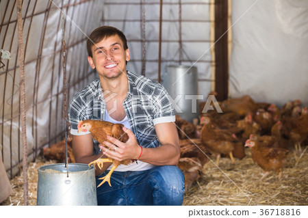 Happy countryman holding brown chicken 36718816