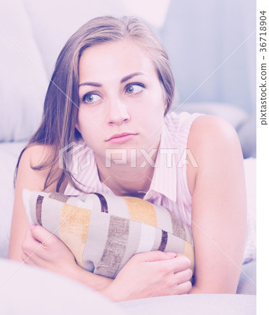 Sad woman on sofa with pillow Sad woman on sofa with pillow 36718904