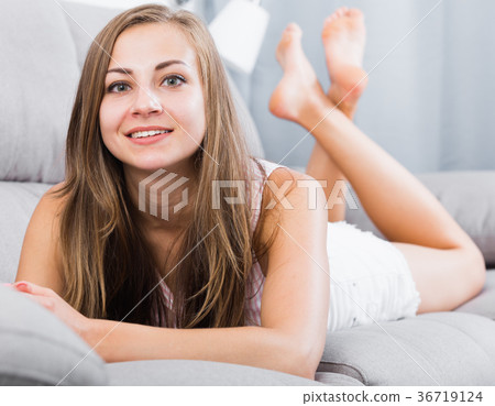 Smiling woman lying on sofa Smiling woman lying on sofa 36719124