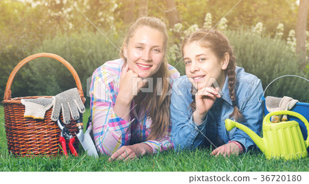 young mother and dauther with gardening tools in outdoors young mother and dauther with gardening tools in outdoors 36720180