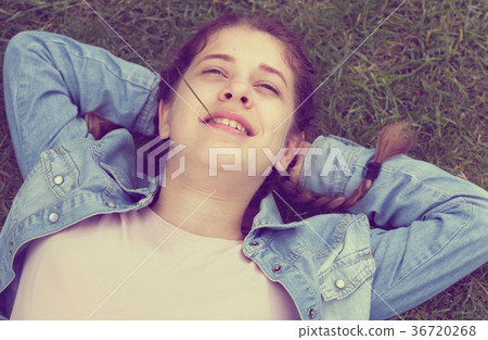 portrait of young female while lying in spring green garden 36720268