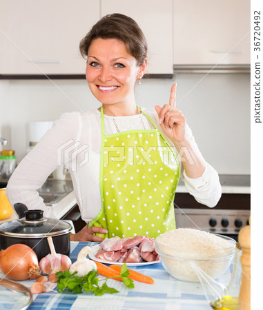 Woman cooking meat with rice . 36720492