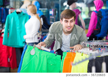 man choosing a sport shorts in the shop man choosing a sport shorts in the shop 36720603
