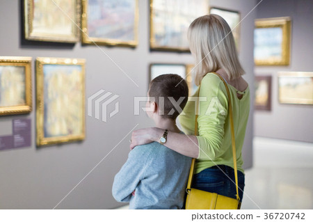Mother and son regarding paintings in halls of museum 36720742