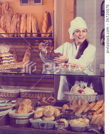 Cafe staff offering cakes for dessert. 36720876
