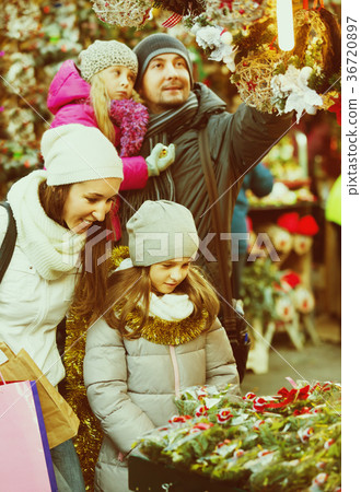 Family standing at coniferous souvenirs counter 36720897