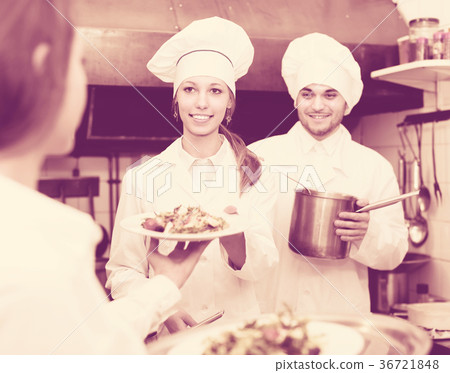 Waitress taking dish from kitchen 36721848