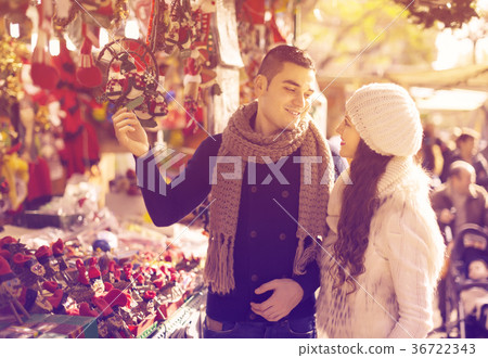 Happy girl with boyfriend choosing Christmas decoration Happy girl with boyfriend choosing Christmas decoration 36722343