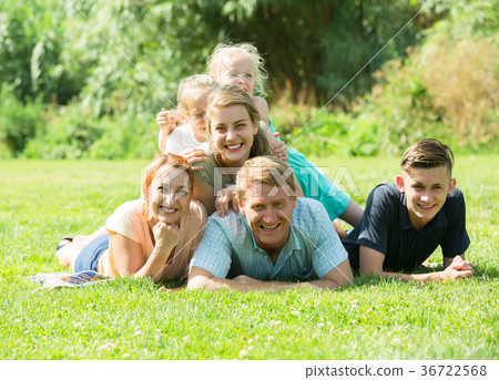 the large family lying on the grass in park. the large family lying on the grass in park. 36722568
