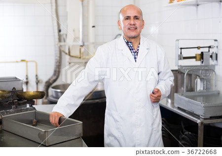 Middle aged worker standing near the table Middle aged worker standing near the table 36722668