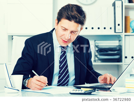Businessman in office clothes filling up documents Businessman in office clothes filling up documents 36722980