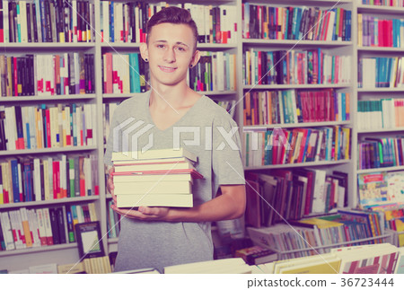 Teenager holding pile of books Teenager holding pile of books 36723444