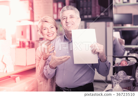 Mature couple buying on credit agreement for home appliances 36723510