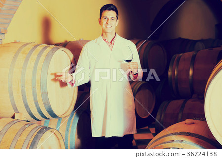 happy man checking ageing process of red wine 36724138