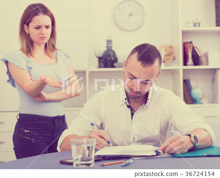 Husband is studying documents on divorce at the table 36724154