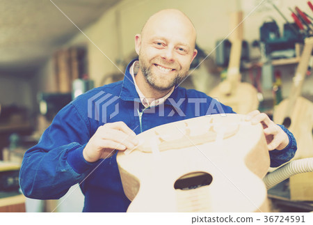 Successful guitar maker in workshop 36724591
