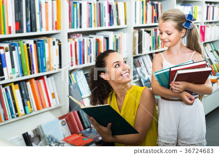 Young smiling woman with child in bookstore 36724683