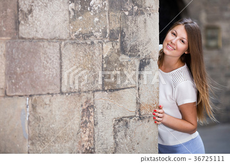 Girl peeking out from behind wall, copyspace 36725111