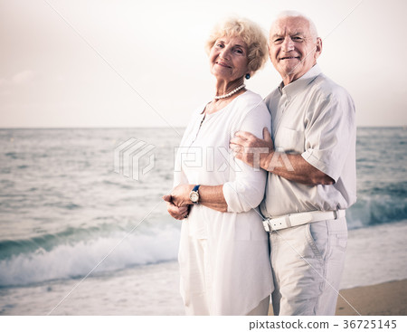 man and woman standing on the sea shore 36725145