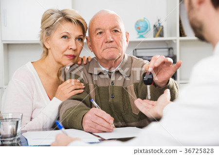 Old man and woman signing car purchase contract Old man and woman signing car purchase contract 36725828