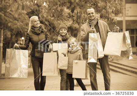 Parents with children shopping in city. 36725830