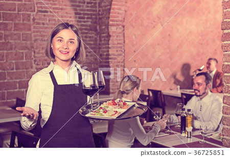 woman waiter demonstrating restaurant to visitors 36725851