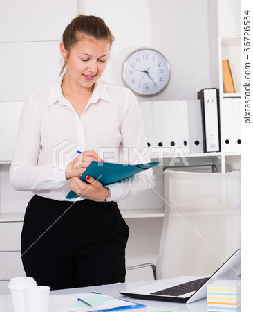 Female office worker is signing agreement papers of financial nature 36726534