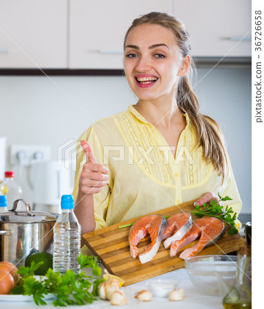 Girl in yellow blouse with fresh salmon fillet Girl in yellow blouse with fresh salmon fillet 36726658