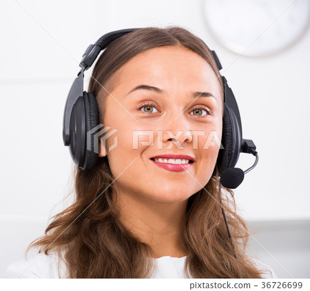 portrait of female operator with headset on answering at call center 36726699