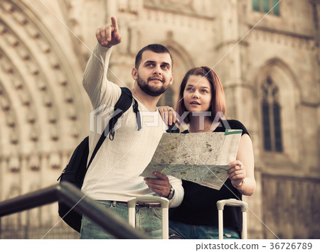 Couple of two young tourists with map walking Couple of two young tourists with map walking 36726789
