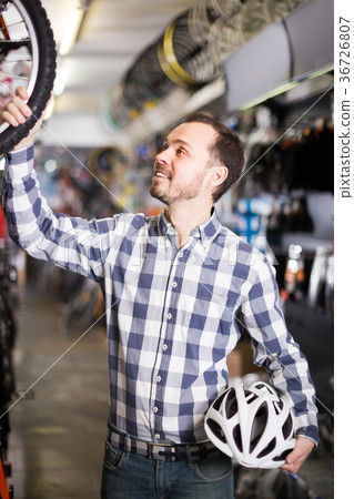 Male 28-34 years old is choosing in sports store convenient bike 36726807