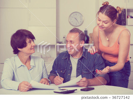 Adult couple is singing contract with their daughter Adult couple is singing contract with their daughter 36727142