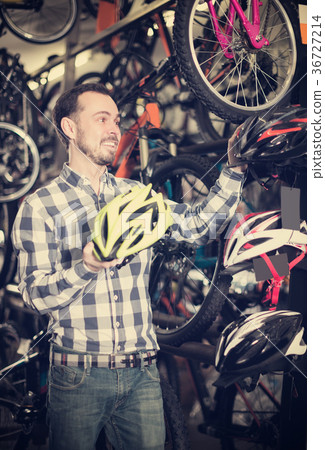 Sporty biker is choosing the safest helmet Sporty biker is choosing the safest helmet 36727214