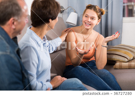 Marrieds with their adult daughter are talking together on sofa Marrieds with their adult daughter are talking together on sofa 36727280