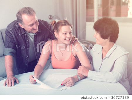 Adult daughter is singing documents with her family Adult daughter is singing documents with her family 36727389
