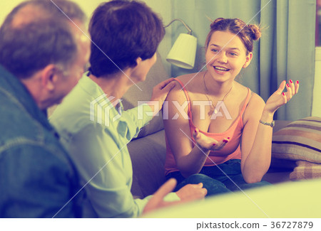 Marrieds with their adult daughter are talking together on sofa Marrieds with their adult daughter are talking together on sofa 36727879