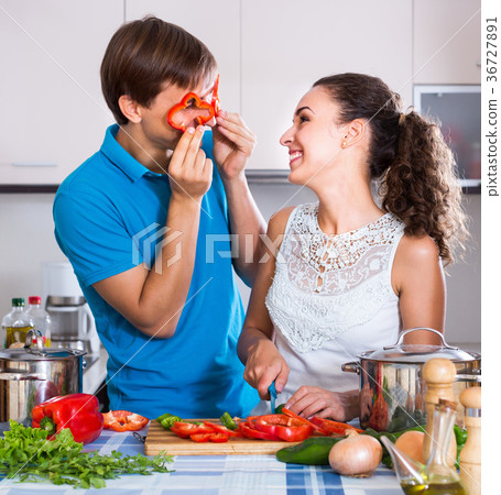 Smiling couple with vegetables near kitchen table Smiling couple with vegetables near kitchen table 36727891