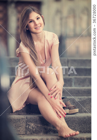 young female in rose dress sitting in city young female in rose dress sitting in city 36728000