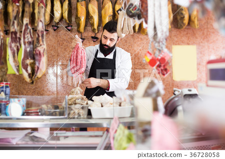 Man shop assistant holding sausages Man shop assistant holding sausages 36728058