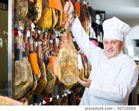 seller in deli shop with iberico and serrano jamon seller in deli shop with iberico and serrano jamon 36728069