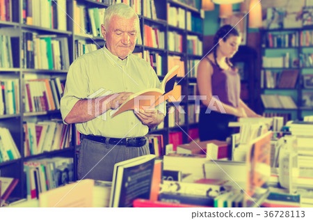 Male 61-67 years old is choosing book for reading in free time Male 61-67 years old is choosing book for reading in free time 36728113