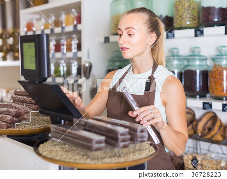 Young woman is standing near cashbox Young woman is standing near cashbox 36728223