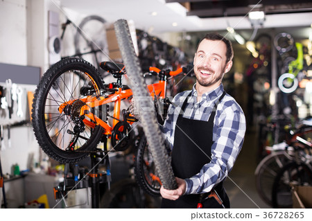 Man change a wheel on a bicycle 36728265