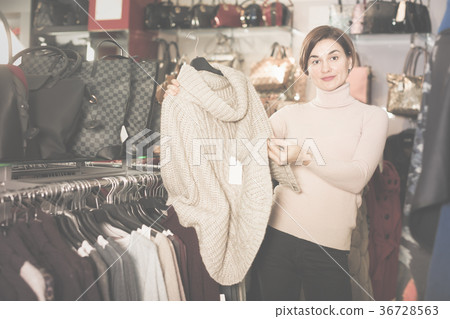 Young woman choosing warm sweater Young woman choosing warm sweater 36728563